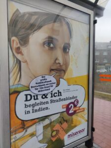 Plakat mit Kind drauf an einer Bushaltestelle mit angeklebter Sprechblase: "Das größte Kohlekraftwerk Deutschlands vor meiner Tür? Ein Grund für Widerstand!"
