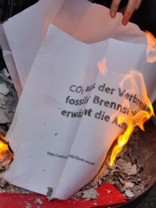 EIn Blatt Papier mit einem Text über die Verbrennung von CO2 wird verbrannt